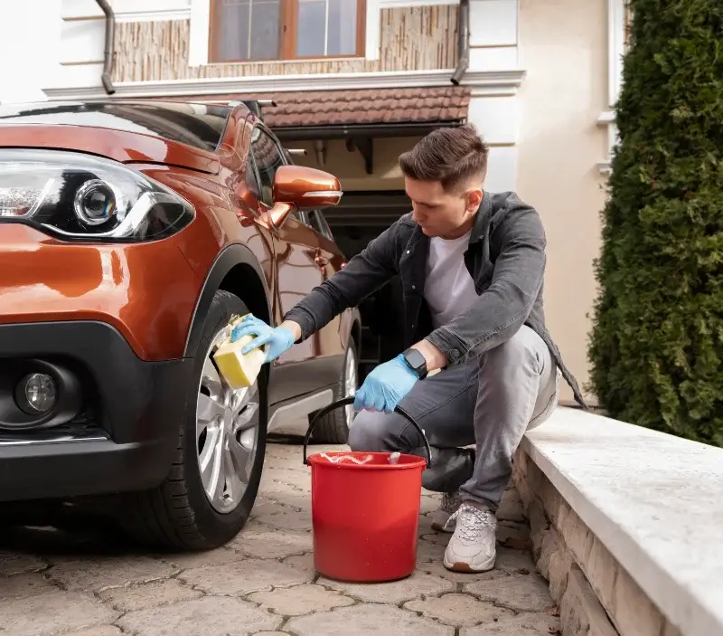 Lavage auto à domicile L'Aigle : professionnel intervenant sur un véhicule